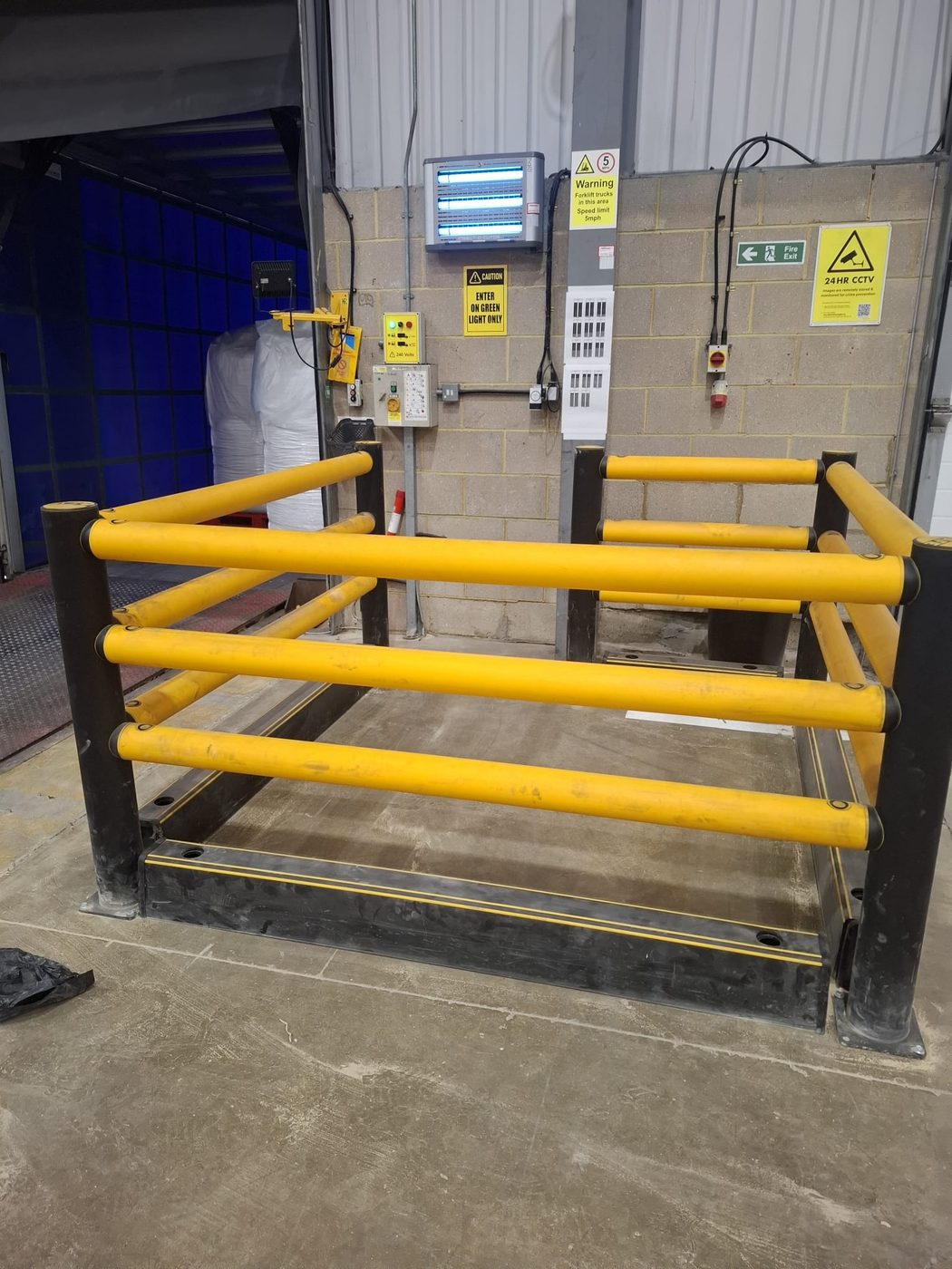 Polymer safety barrier installed around a loading bay dock leveller at a distribution warehouse in Sudbury by Eastrada Facilities