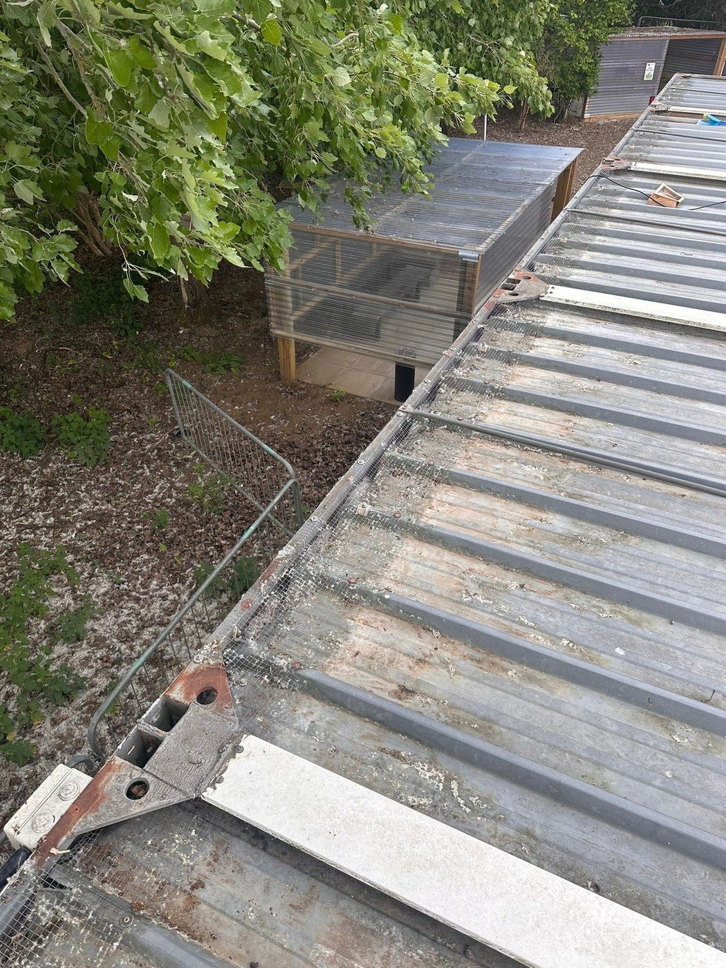 Close-up of a commercial gutter blocked with heavy organic debris before Eastrada vacuum clearing